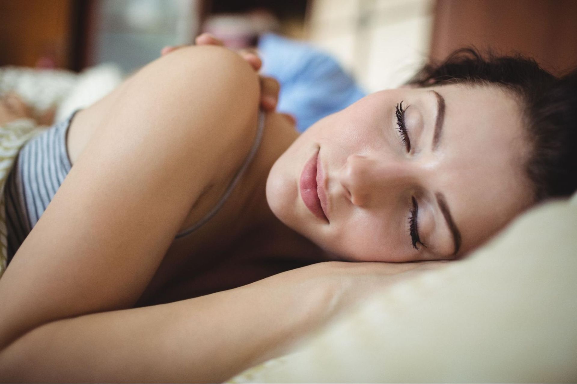 Woman sleeping with a man putting his hand on her shoulder. 