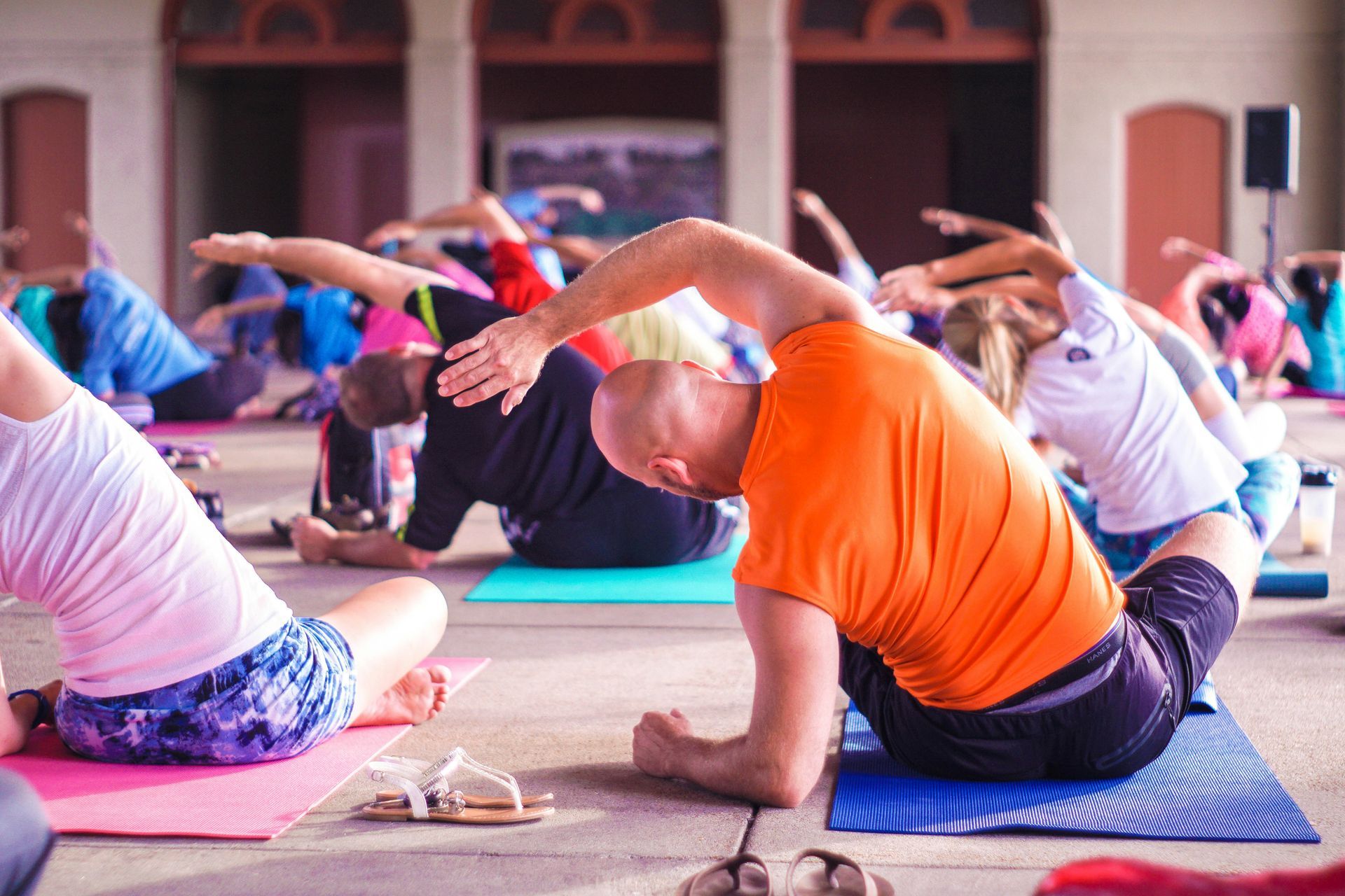 People doing yoga poses on mats outdoors.