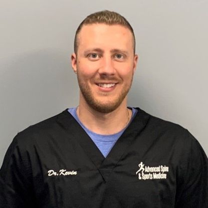 Dr. Kevin, a man with a beard and short hair, wearing a black shirt with logo