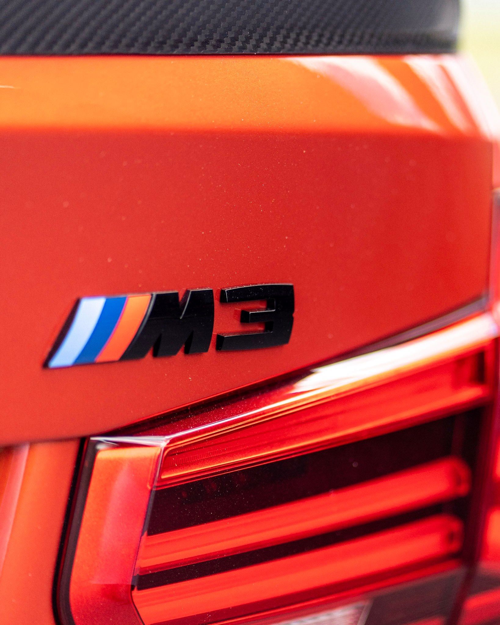 A close up of the rear end of an orange bmw m3