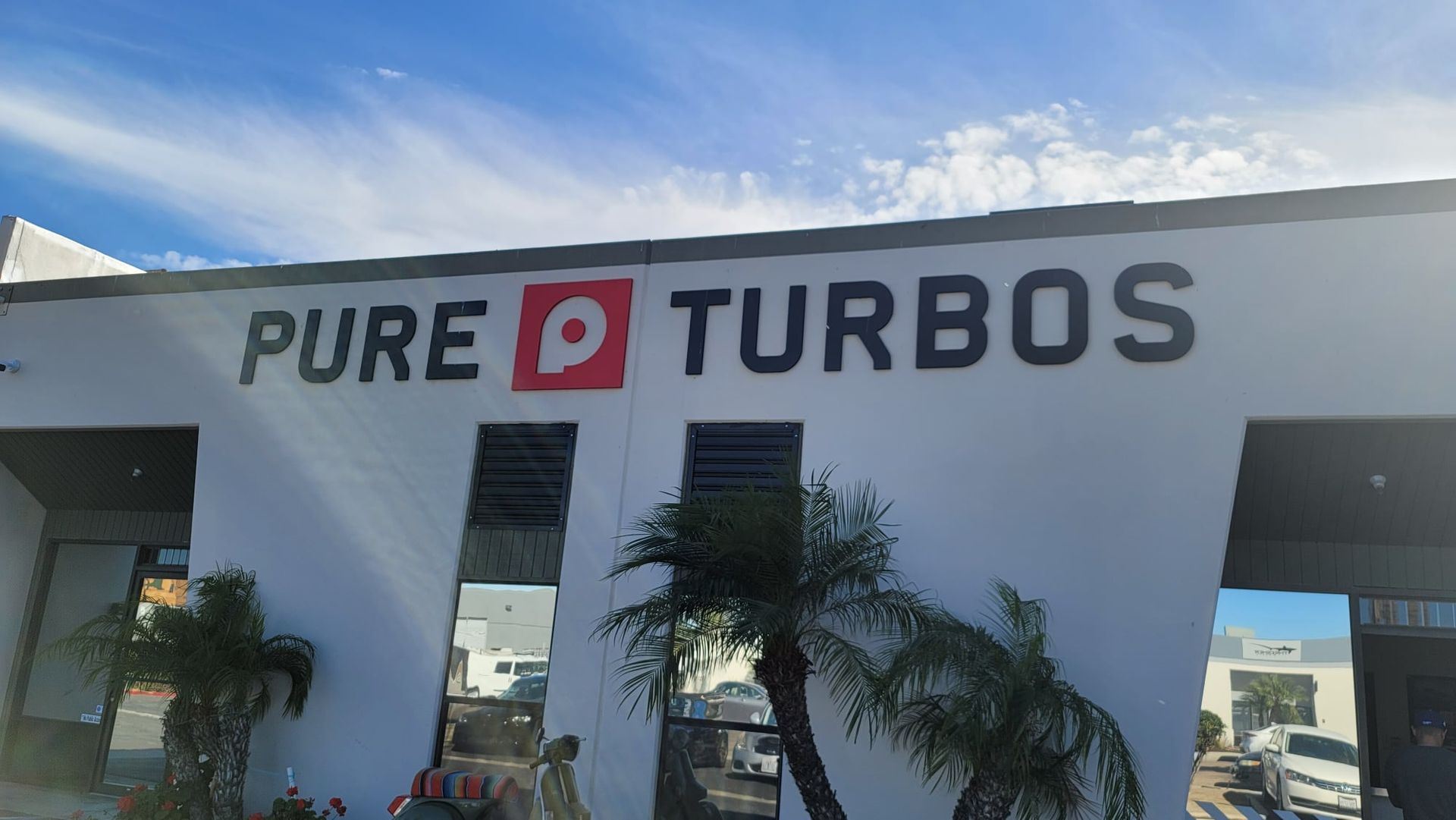 A white building with a sign that says pure turbos on it.