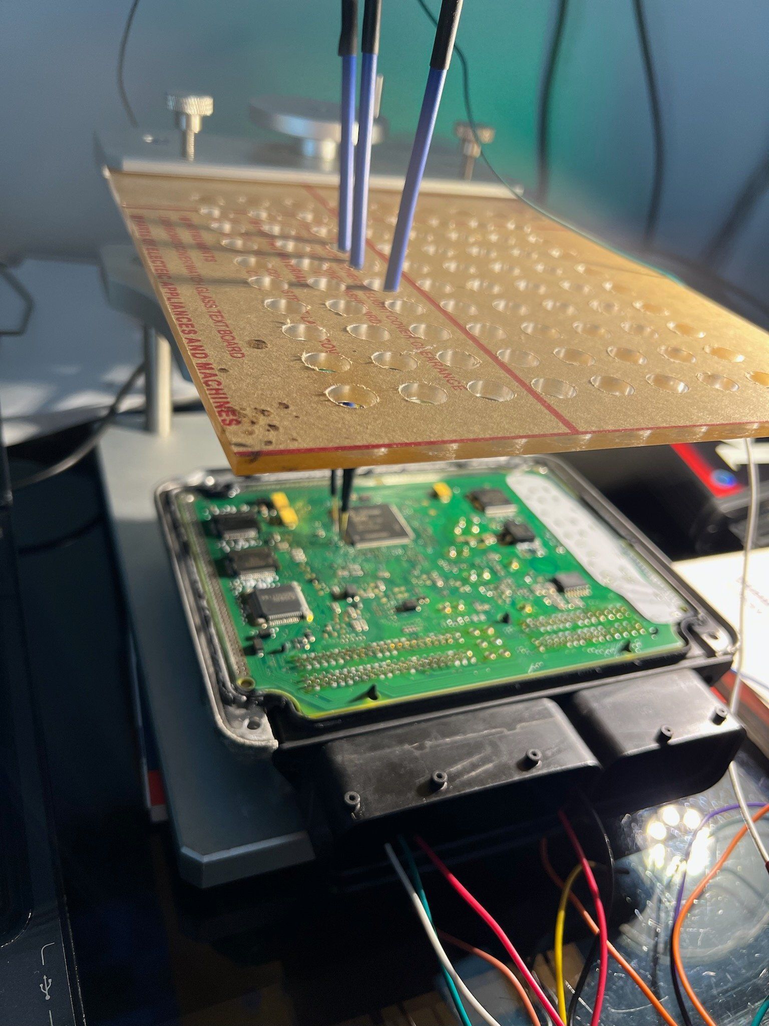 A motherboard is sitting on top of a piece of acrylic on a table.