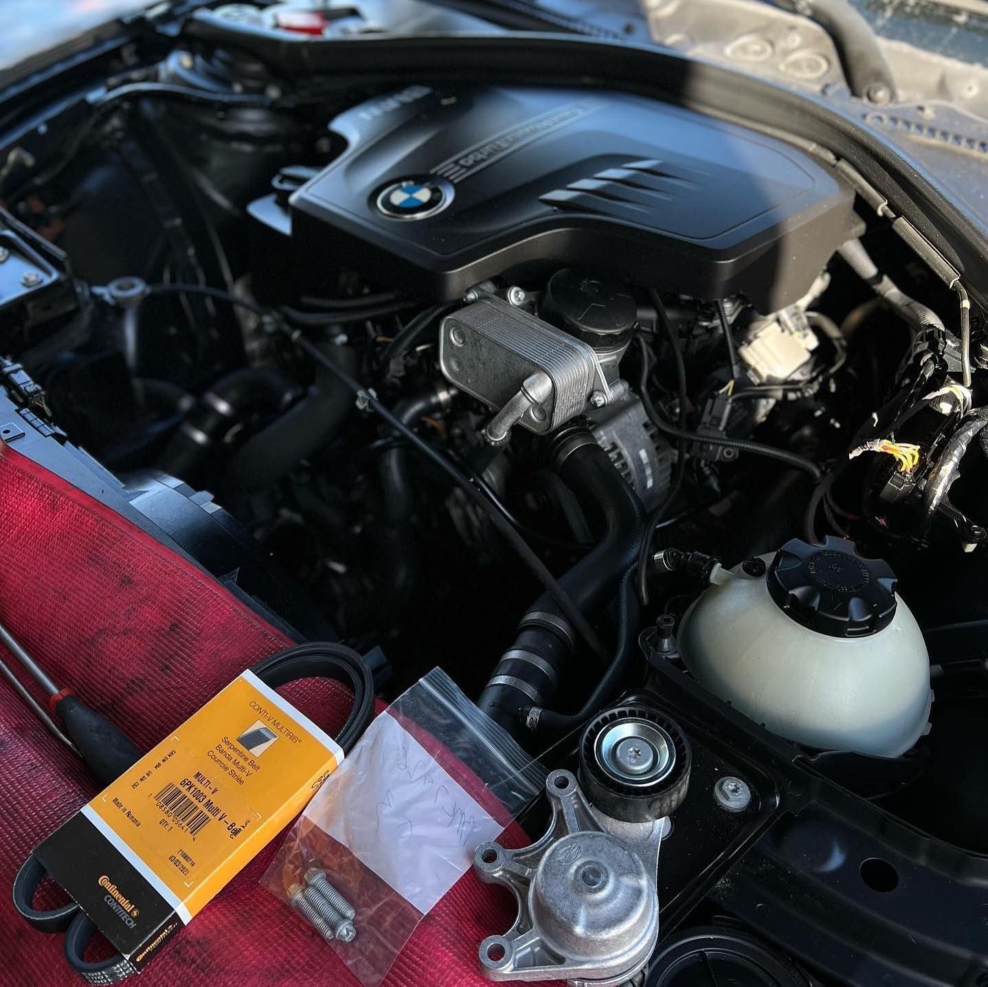 A close up of a car engine with a yellow box that says ' bmw ' on it