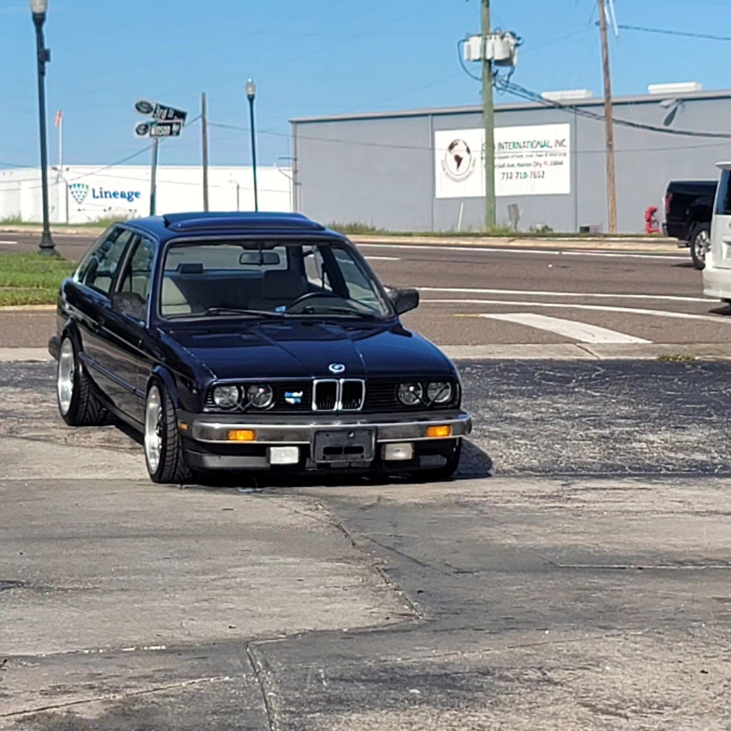 A black bmw is parked in a parking lot
