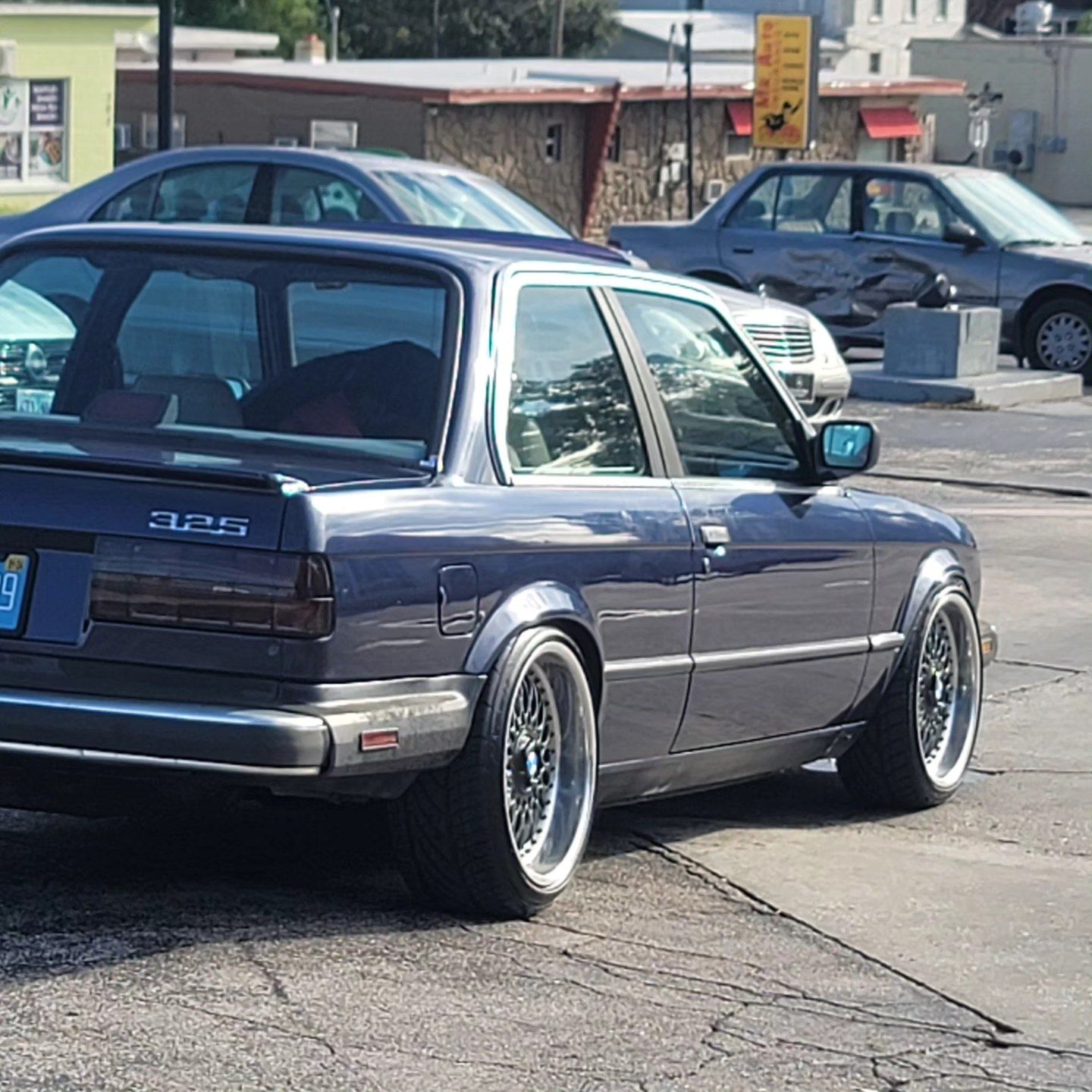 A bmw 325 is parked in a parking lot