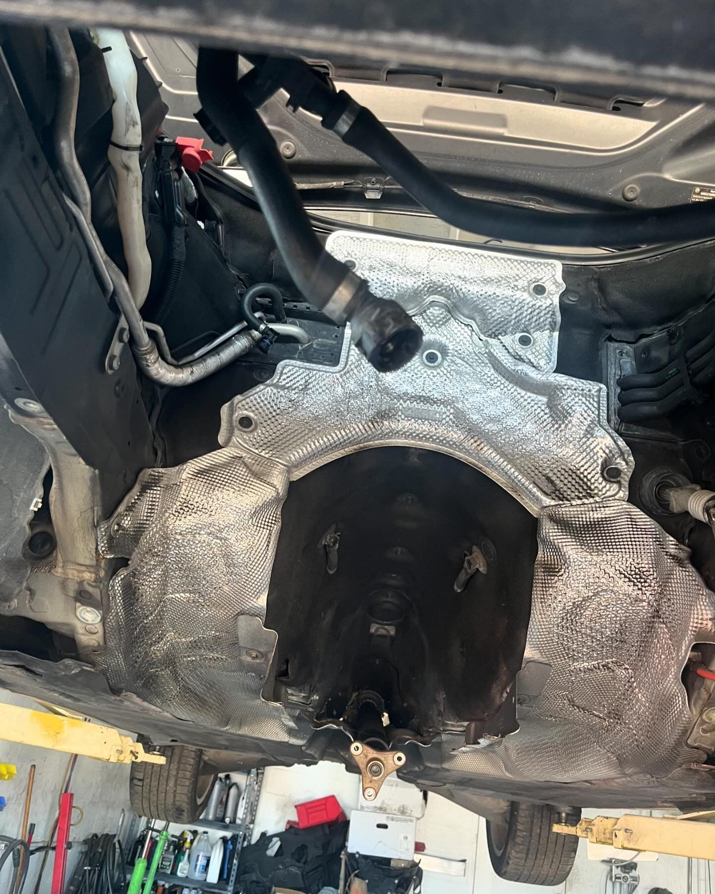 A close up of the underside of a car in a garage.