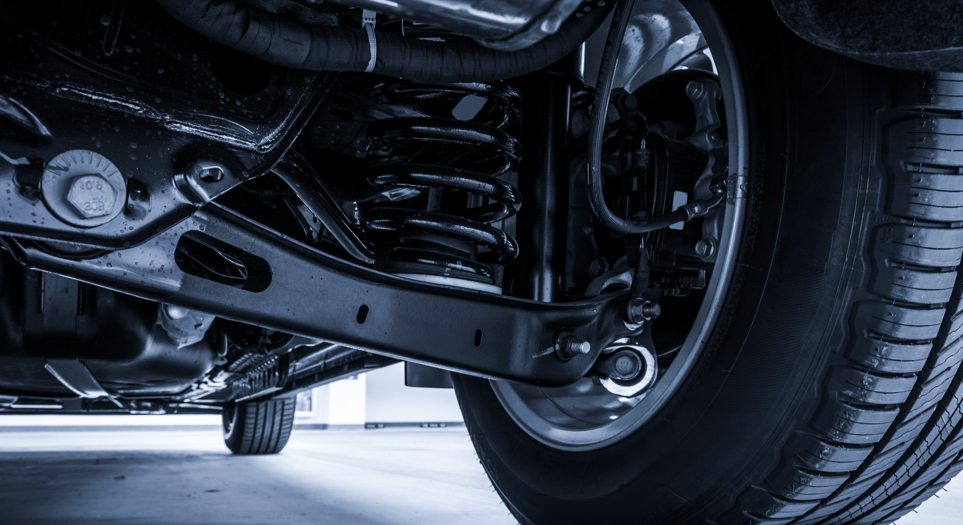 A close up of the underside of a car with a tire.