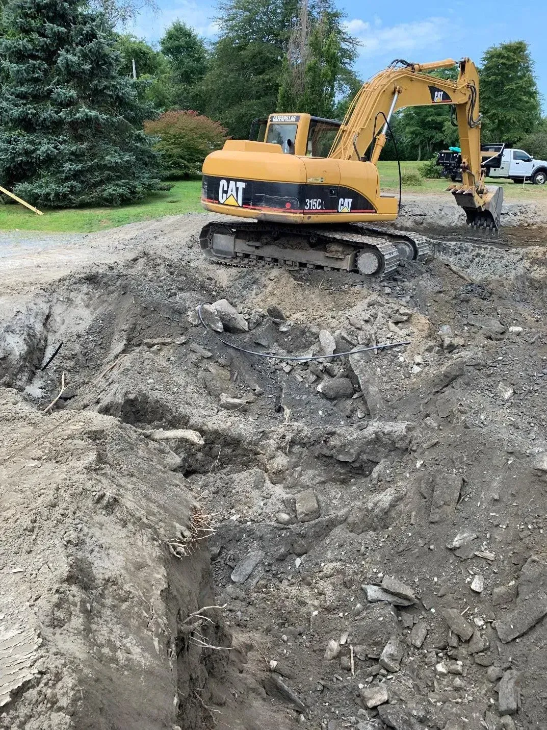 Yellow CAT excavator digging in a dirt pit outdoors. Yellow CAT excavator digging in a dirt pit outdoors.