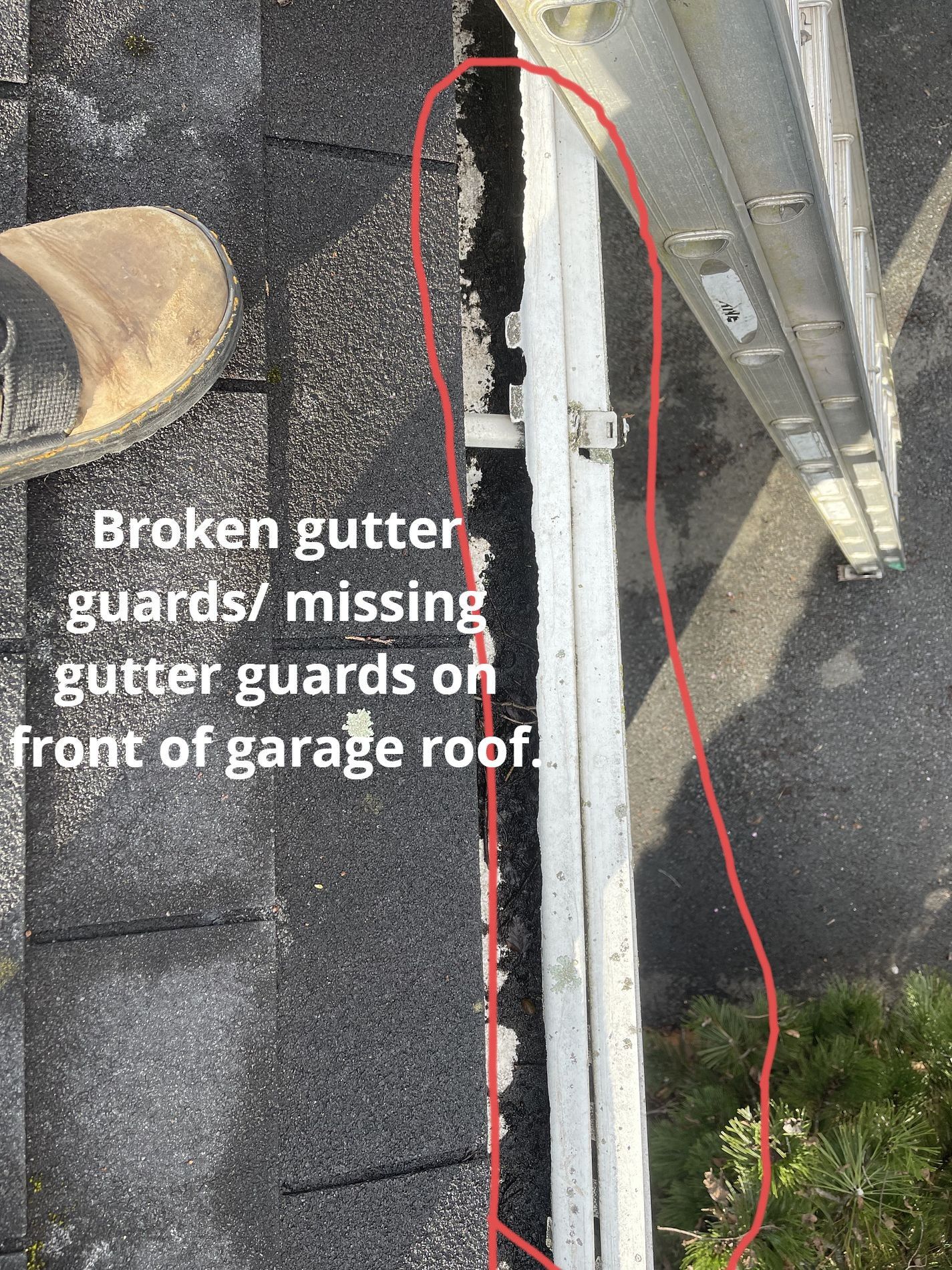 A close-up view from a roof showing damaged or missing white gutter guards along the edge of a garage roof.