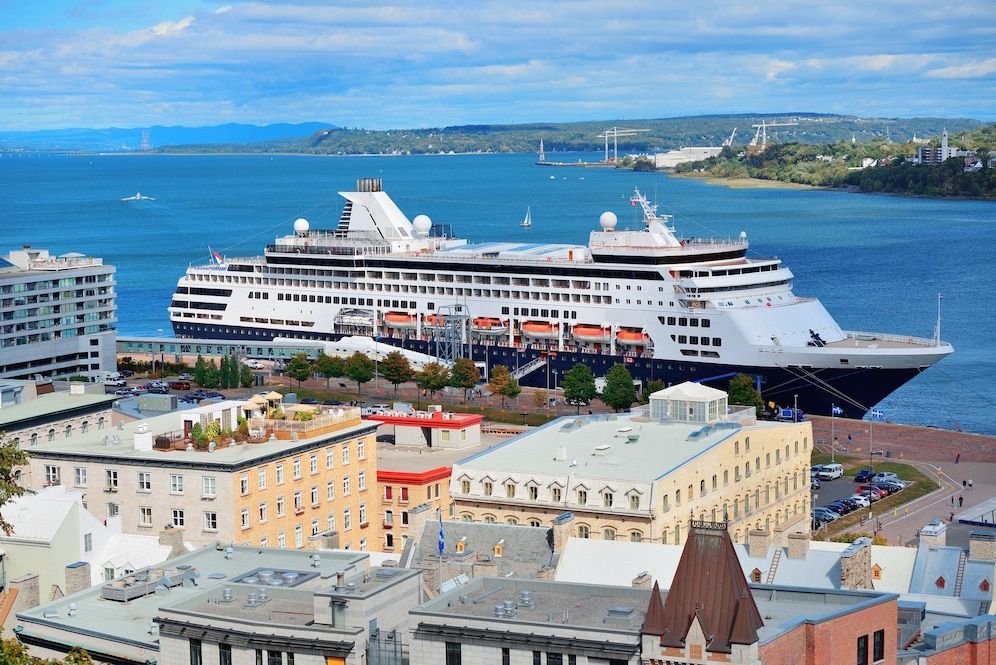 A large cruise ship is docked in a harbor next to a city.