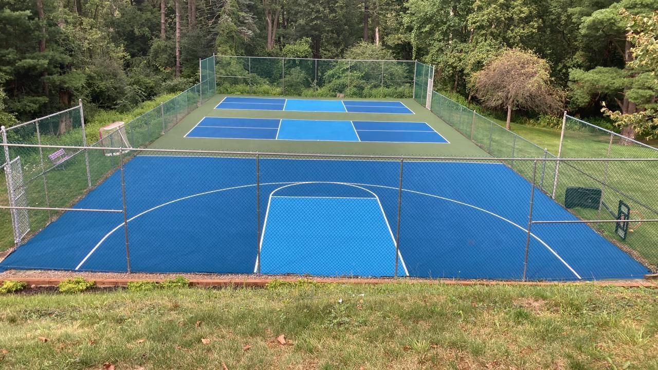 A blue tennis court with a fence around it