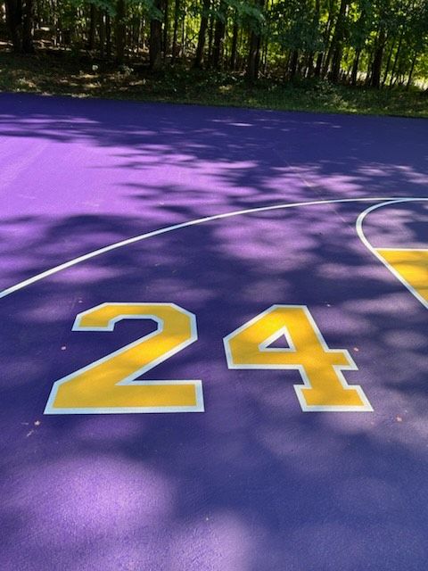 A purple basketball court with the number 24 painted on it
