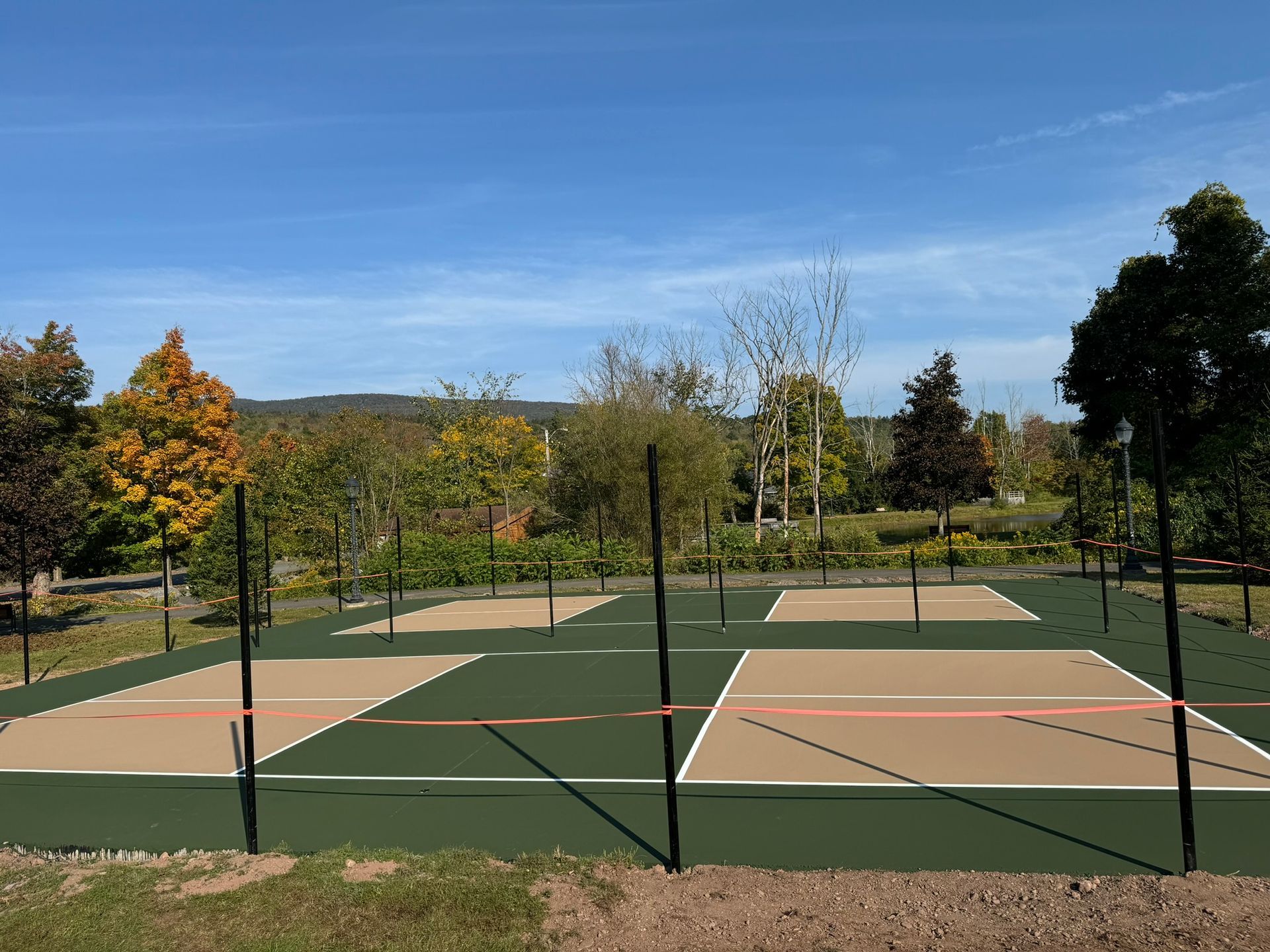A volleyball court in a park with trees in the background