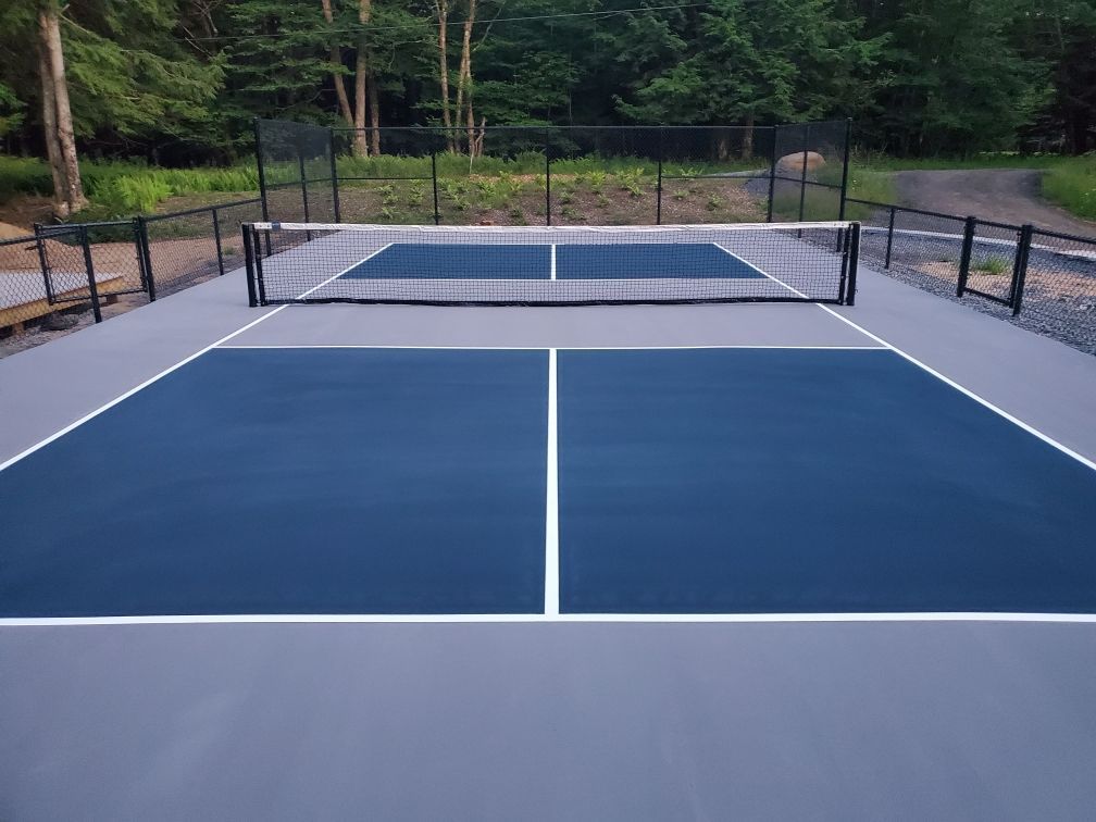A tennis court with a net and trees in the background.