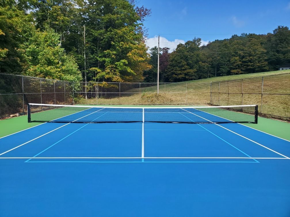 A tennis court with a net and trees in the background