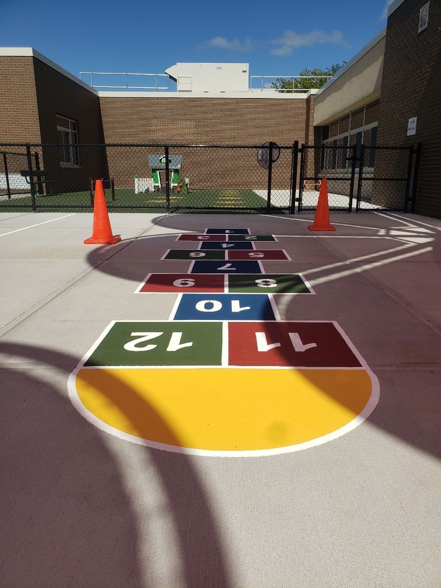 A colorful hopscotch game is painted on the ground