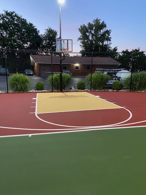 A basketball court with a house in the background