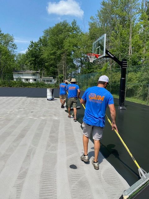 A group of men are working on a basketball court.