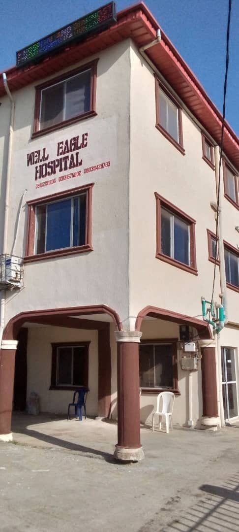 A large white building with a sign that says well eagle hospital