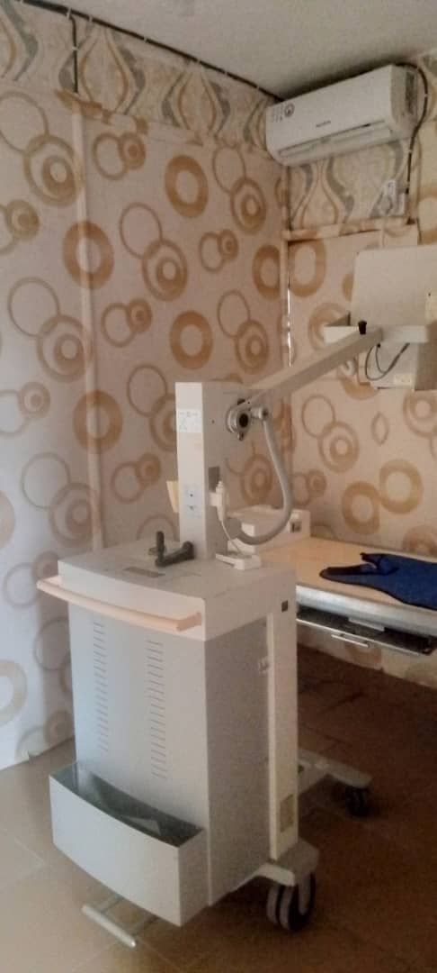 A hospital room with a bed and a machine on wheels.