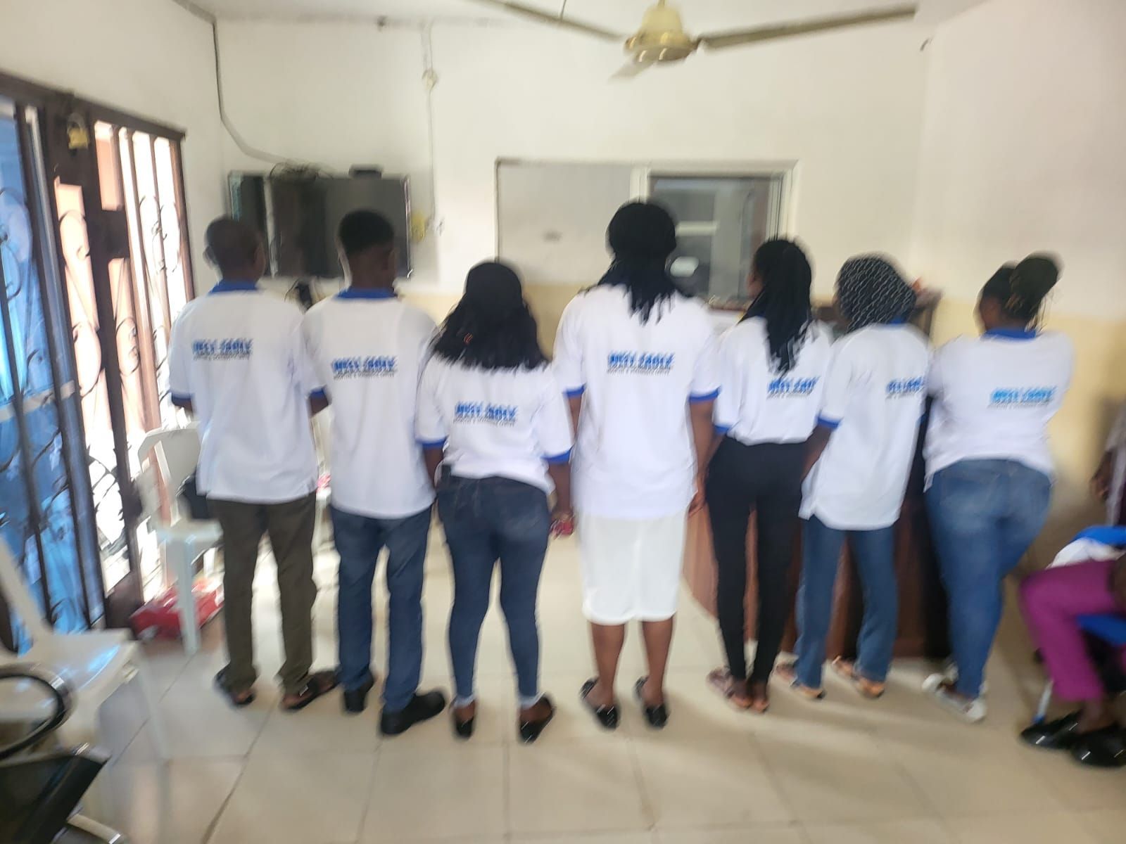 A group of people standing in a room wearing white shirts that say miami