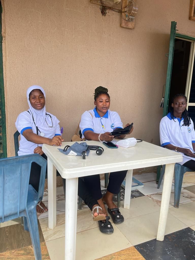 Three women are sitting at a table with a stethoscope on it.