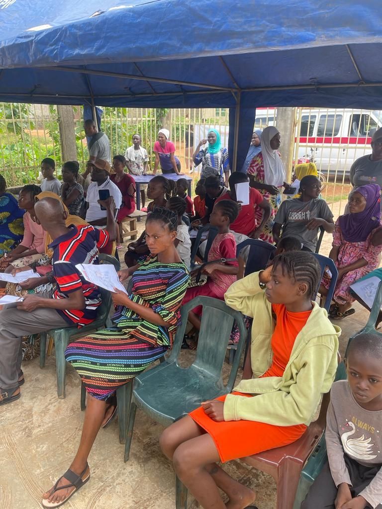 A group of people are sitting under a tent.