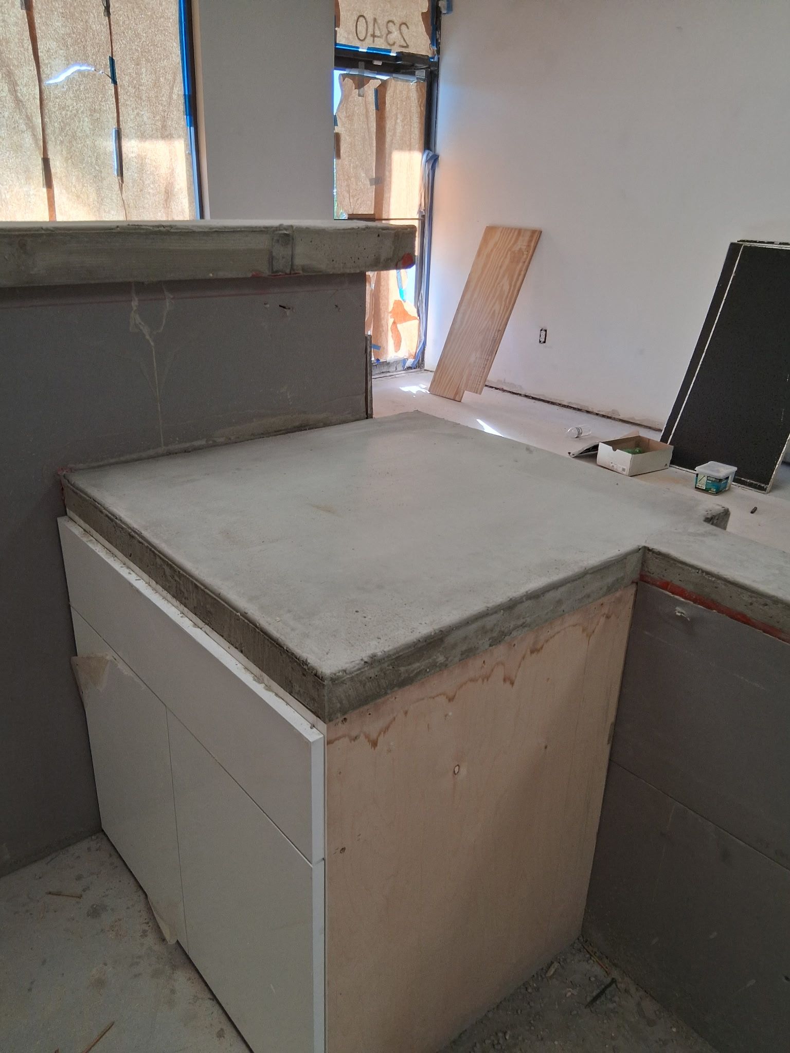 Concrete countertop and cabinet under construction indoors.