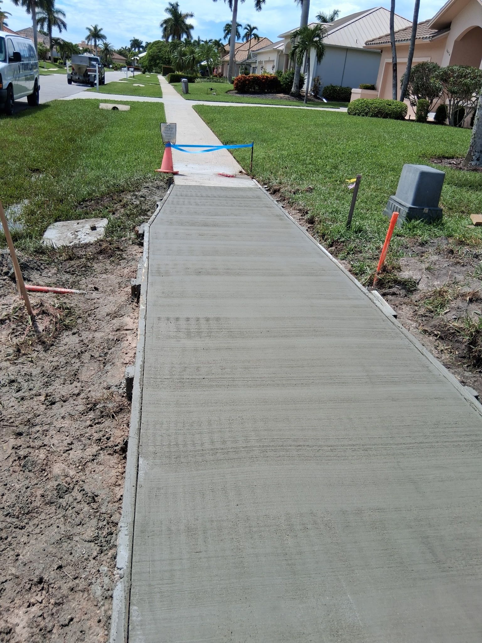 Newly poured concrete sidewalk in a residential neighborhood.