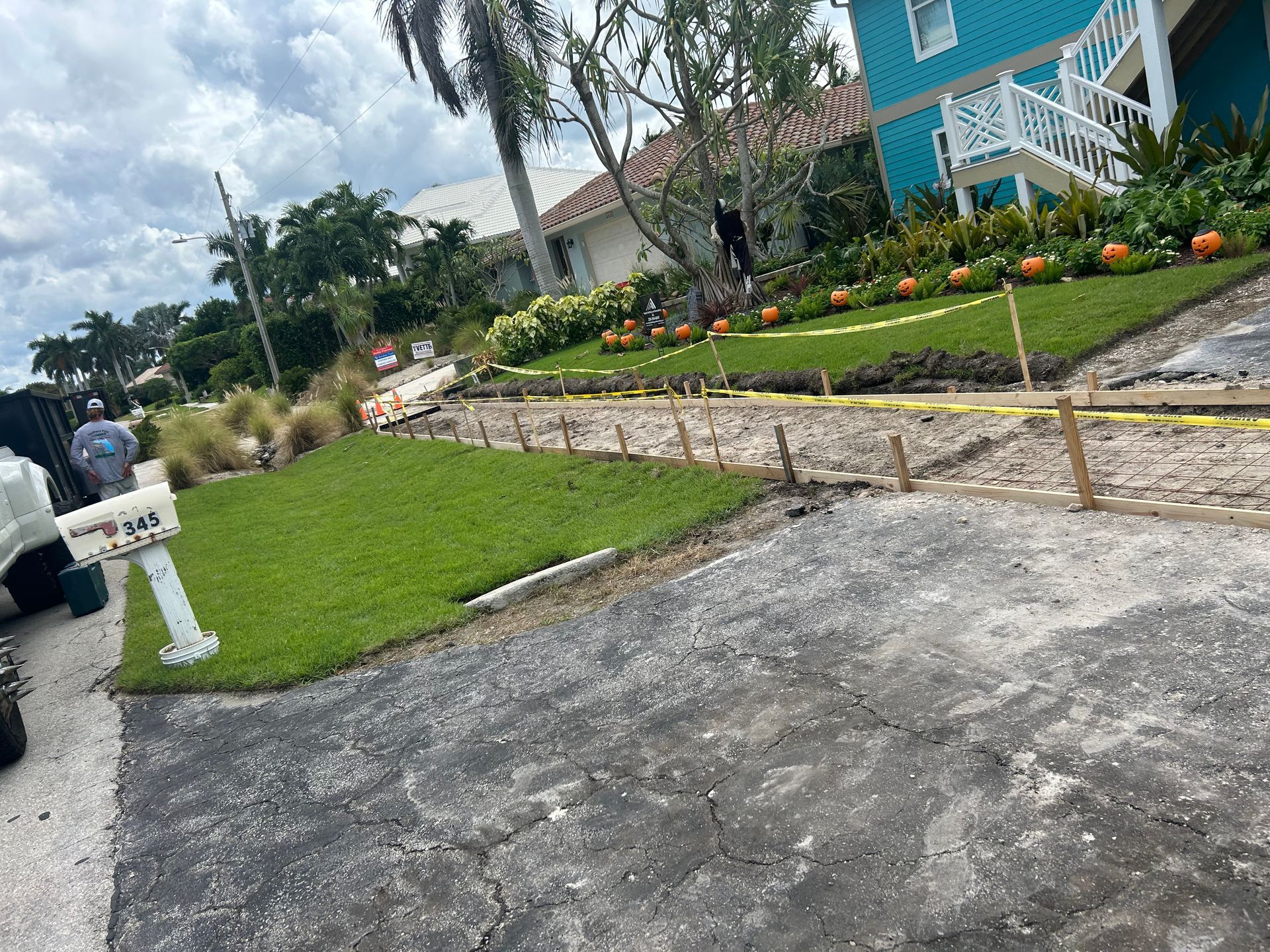 Street view of landscaping in progress with new grass and construction barriers.