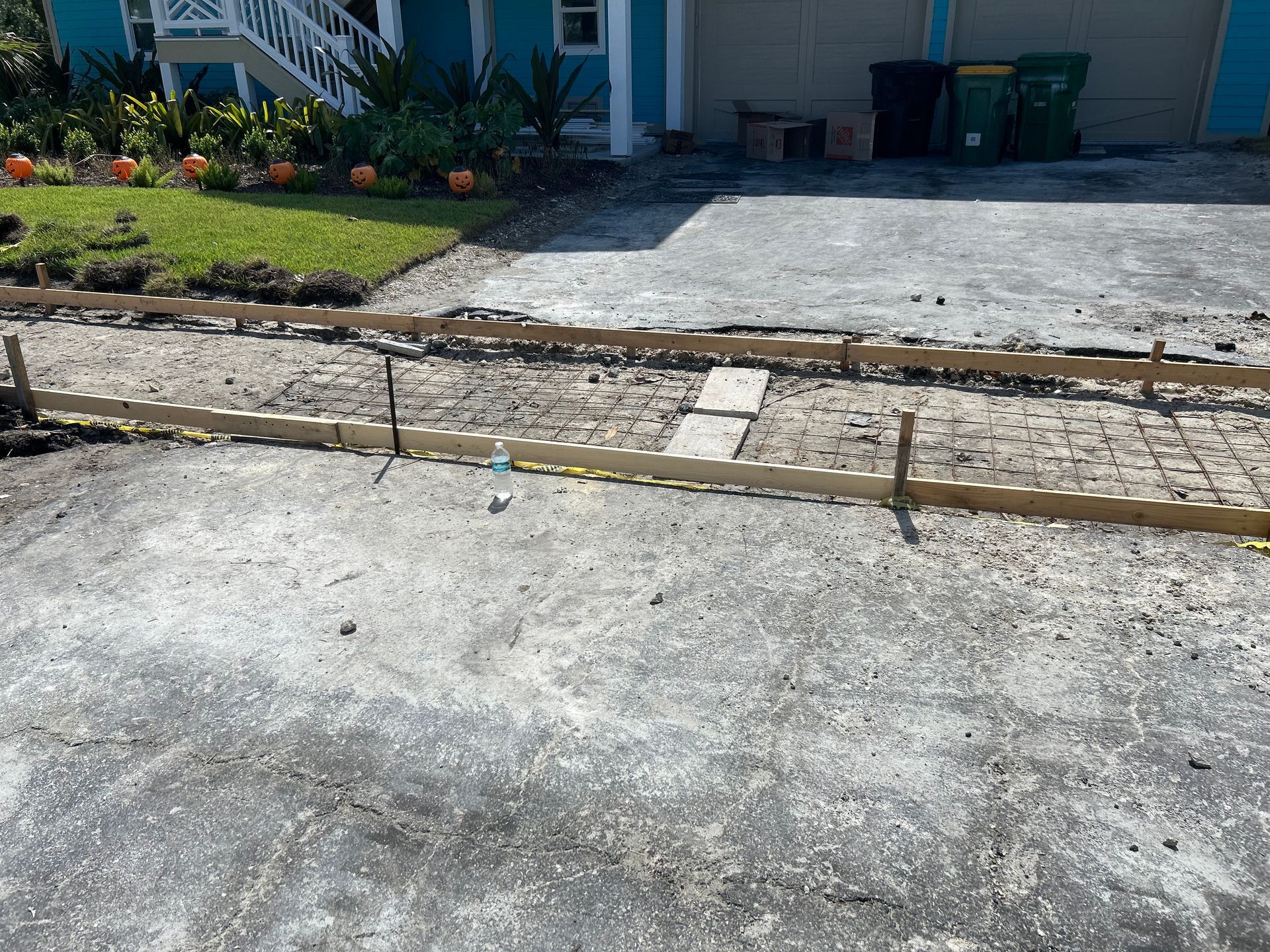 Driveway construction: wooden forms define a path. Gravel bed prepared for concrete.