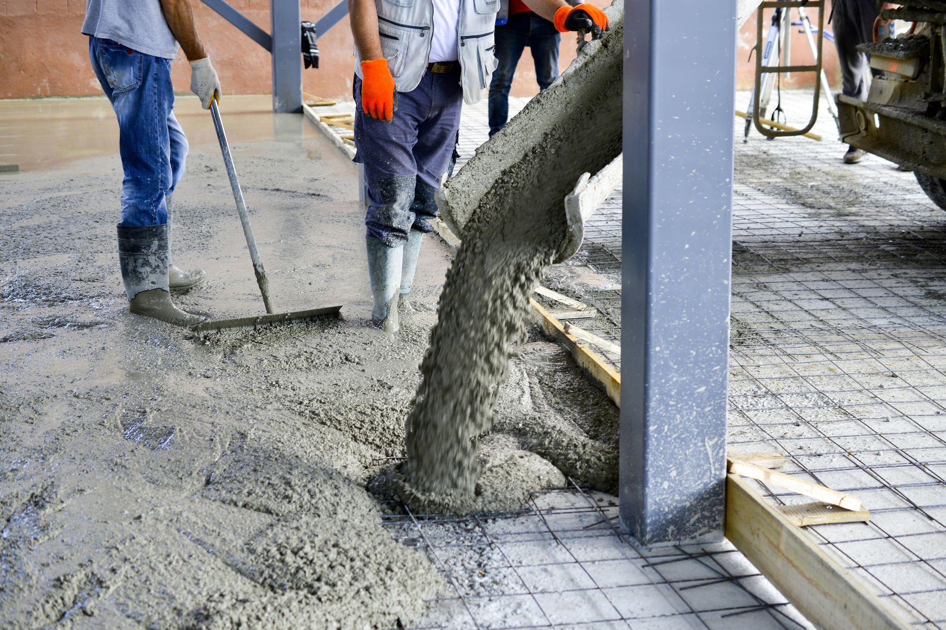 A group of men are working on a concrete driveway.
