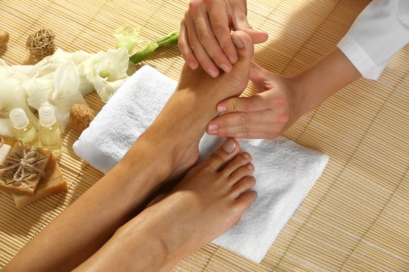 A woman is getting a foot massage at a spa