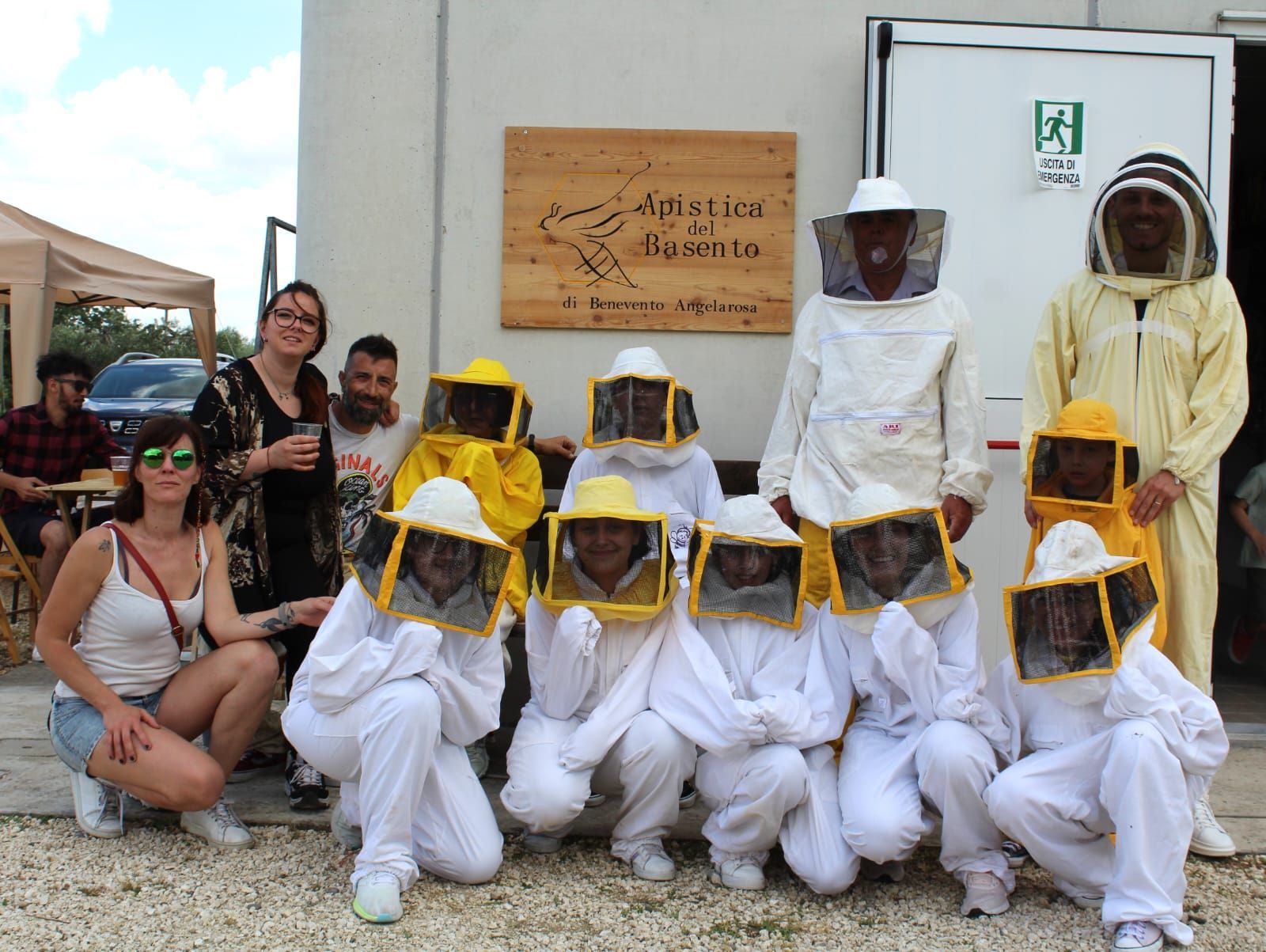 Un gruppo di persone che indossano tute da apicoltore posano per una foto.
