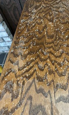 Overhead view of a light green house with a gray metal roof, garage, and landscaping.