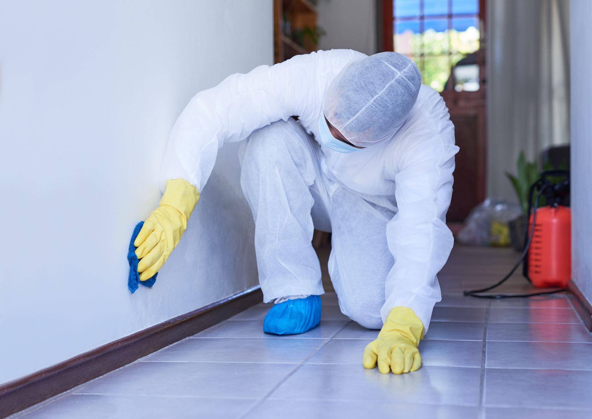 Yellow house with a two-car garage, lush green lawn, and blue sky with clouds.