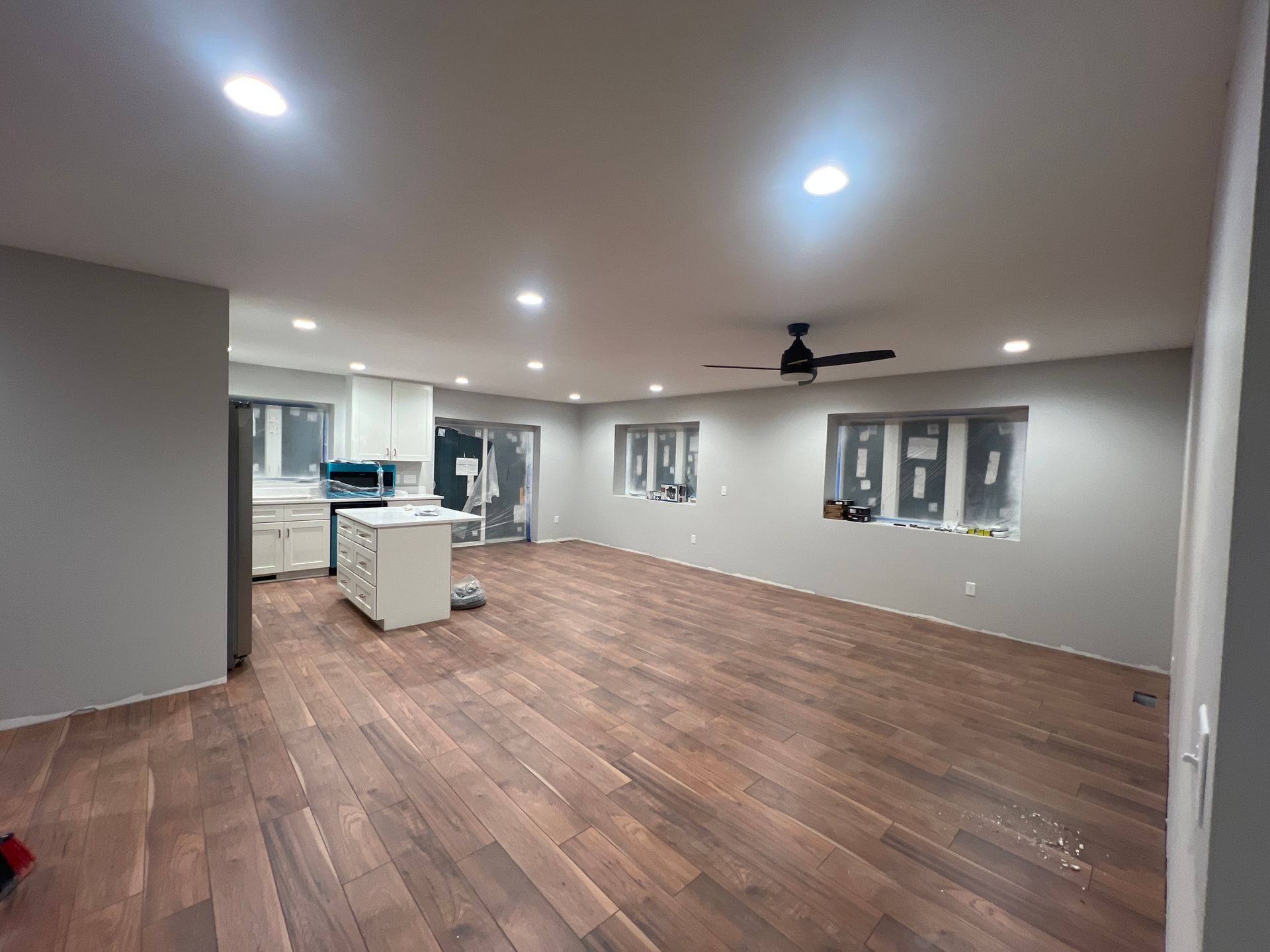 Yellow house with a two-car garage, lush green lawn, and blue sky with clouds.