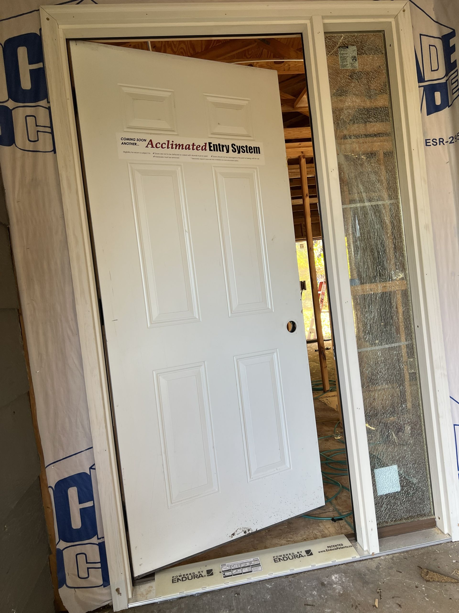 Overhead view of a gray shingled roof on a house with surrounding grass and a glimpse of a pool enclosure.