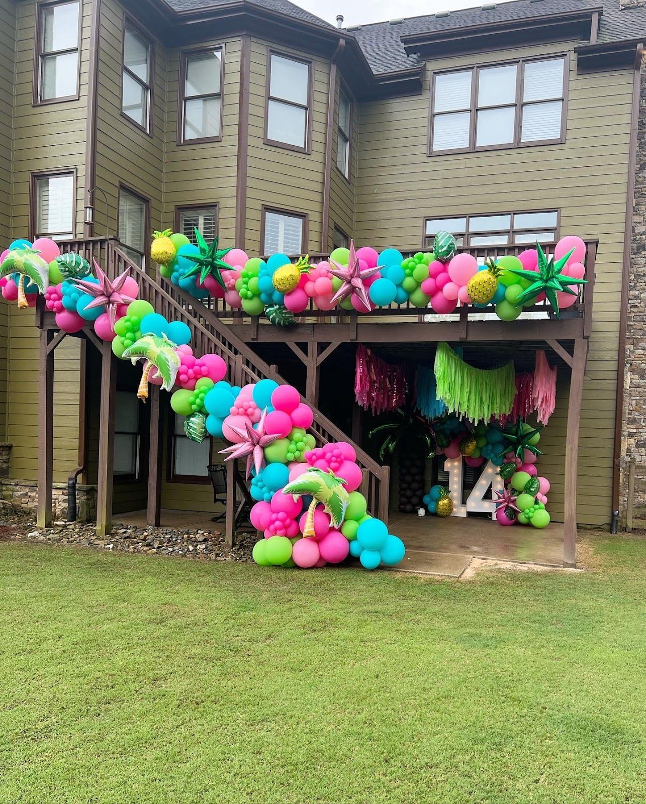 Outdoor deck decorated with colorful balloons for a 14th birthday.