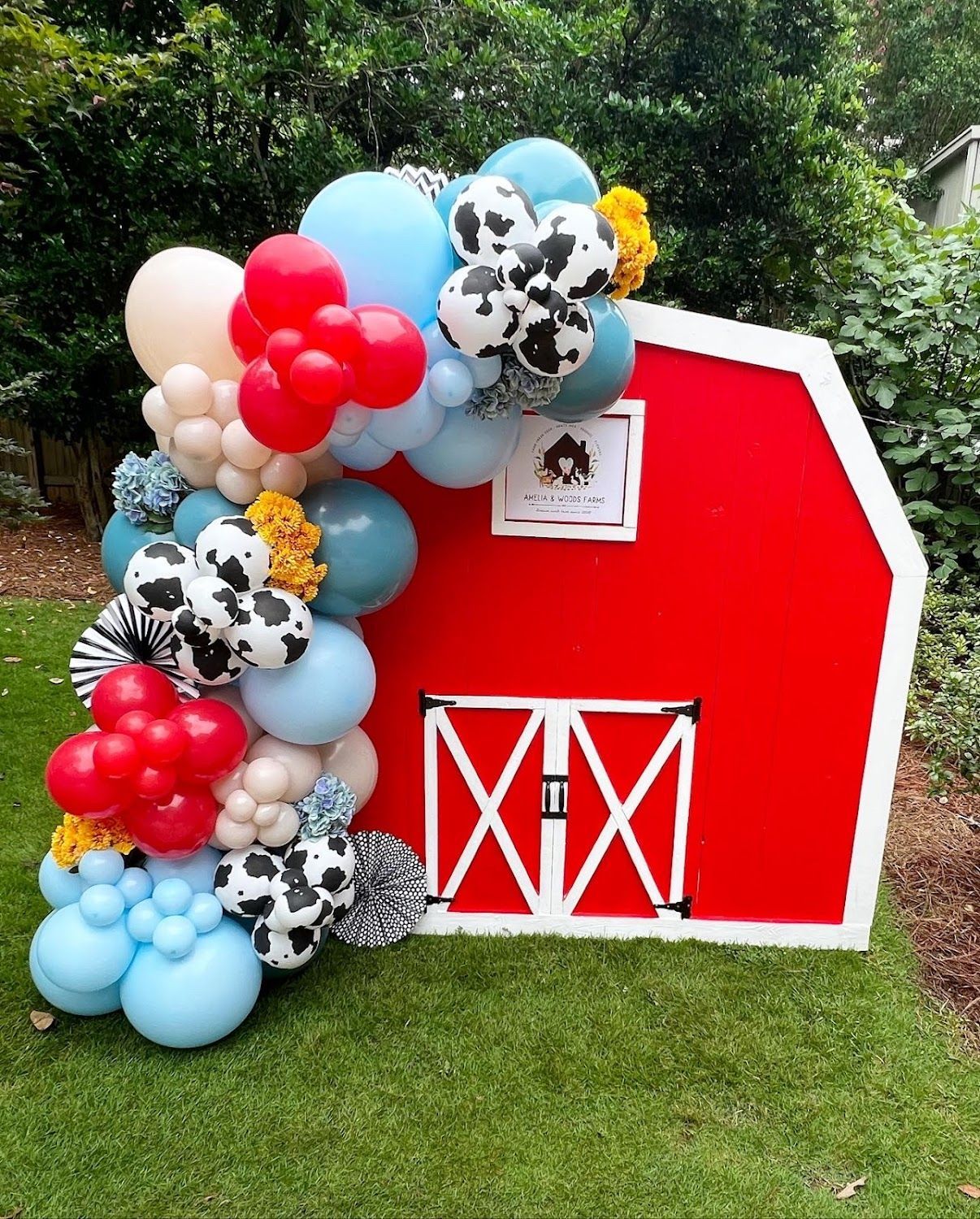 Red barn cutout with a balloon garland.
