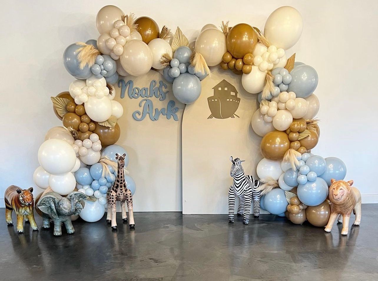 Balloon arch backdrop with animal figurines for a 
