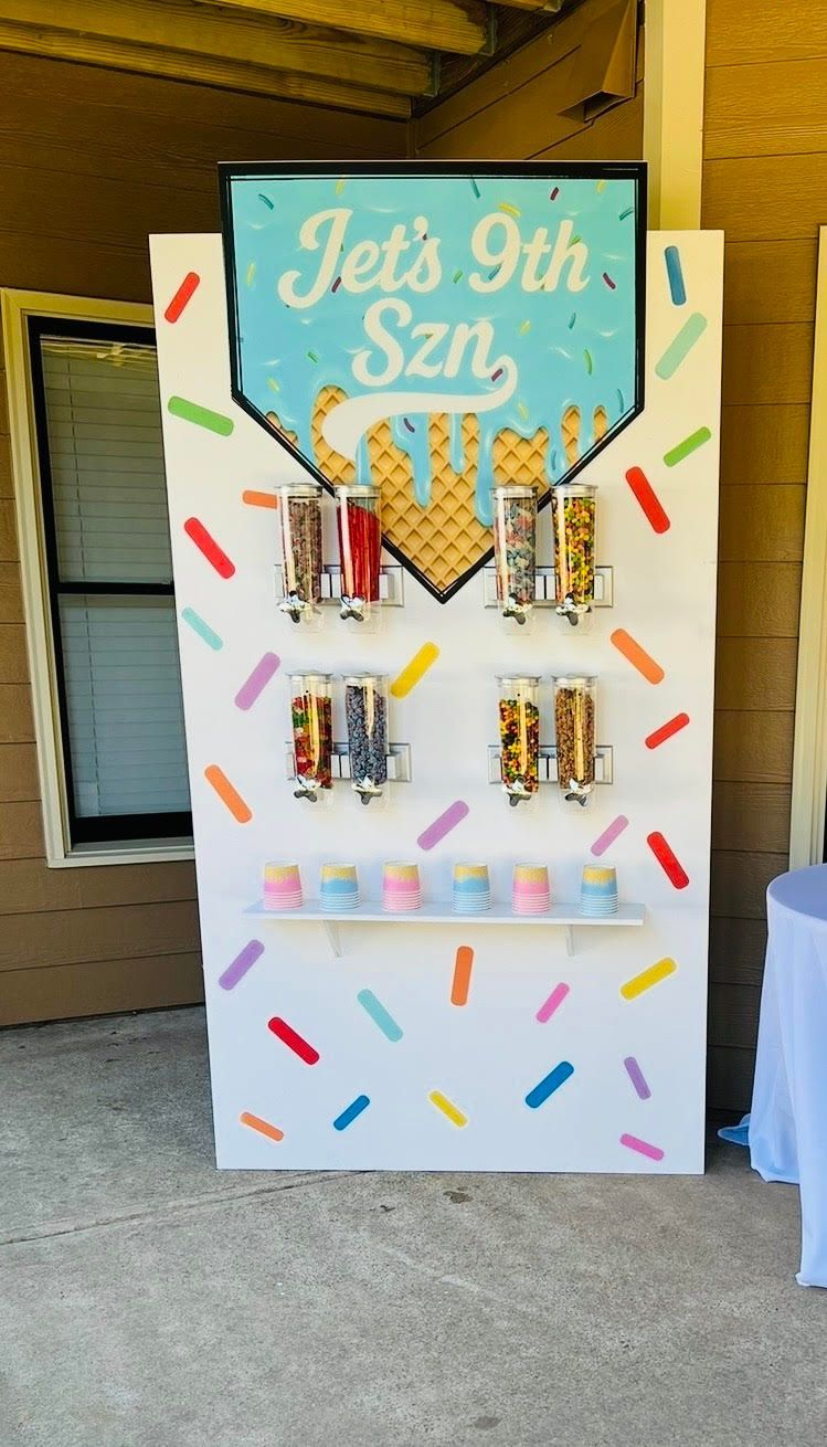 A white game board with sprinkle decorations, featuring prizes, and the words 