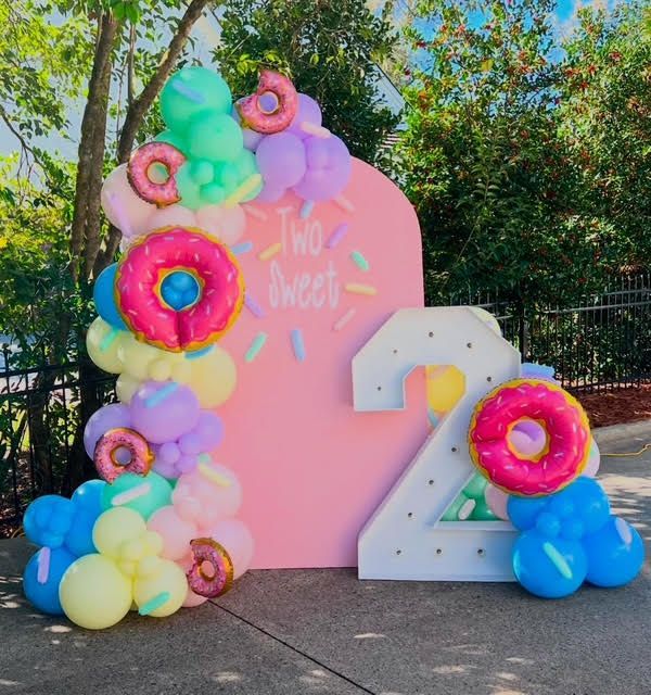 Donut-themed second birthday backdrop: pink panel with 