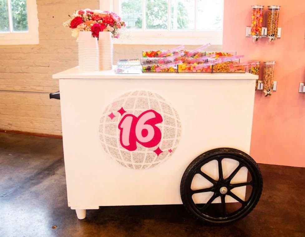 White candy cart decorated for a Sweet 16, with sweets, flowers, and a disco ball graphic.