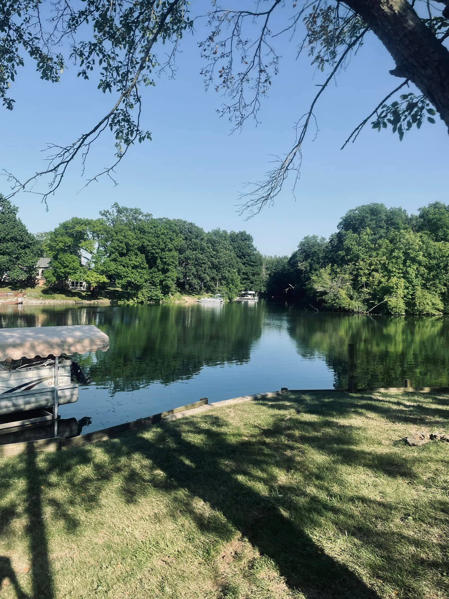 A large body of water surrounded by trees and a dock.