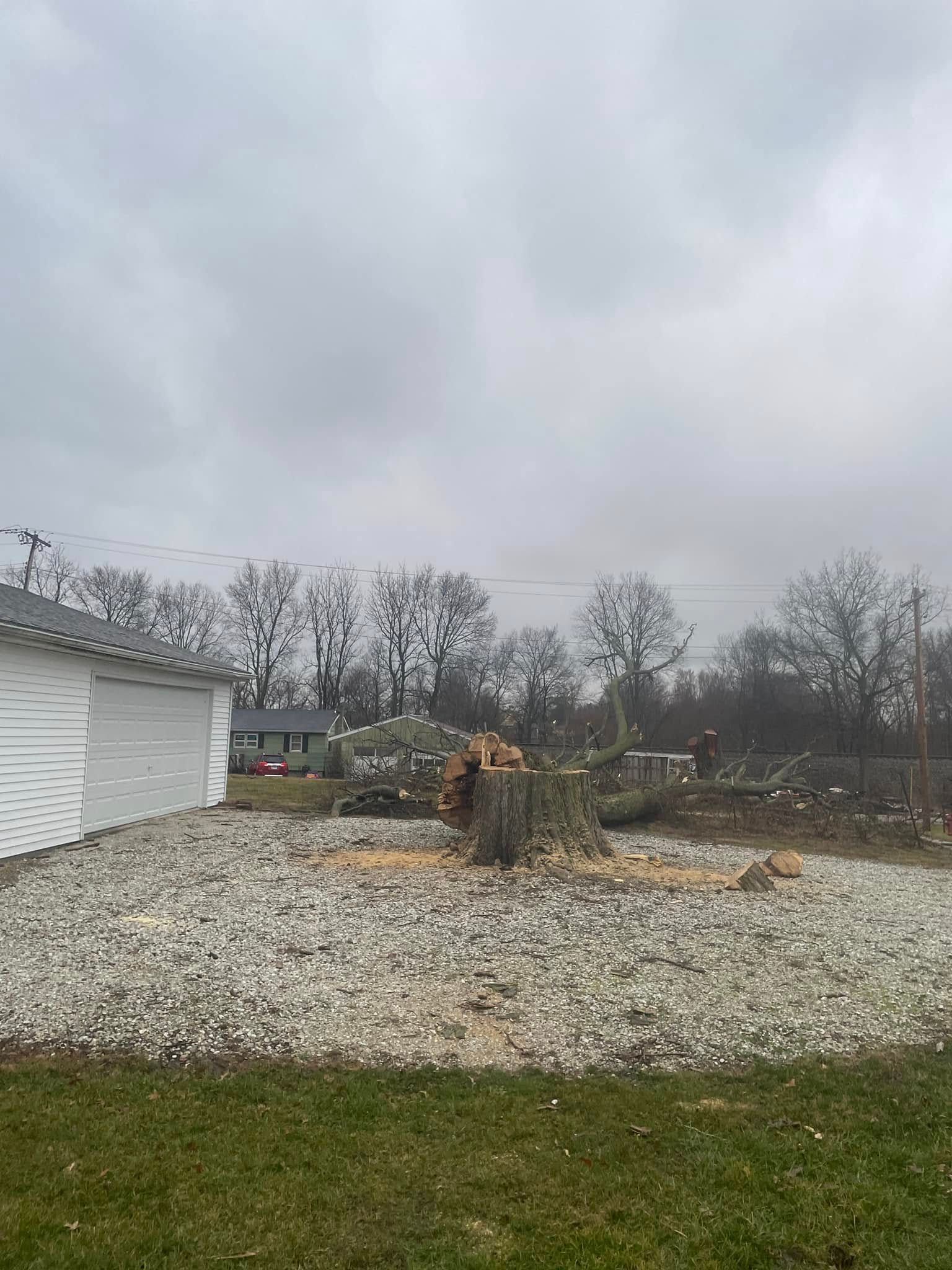 A white garage is sitting in the middle of a gravel lot.