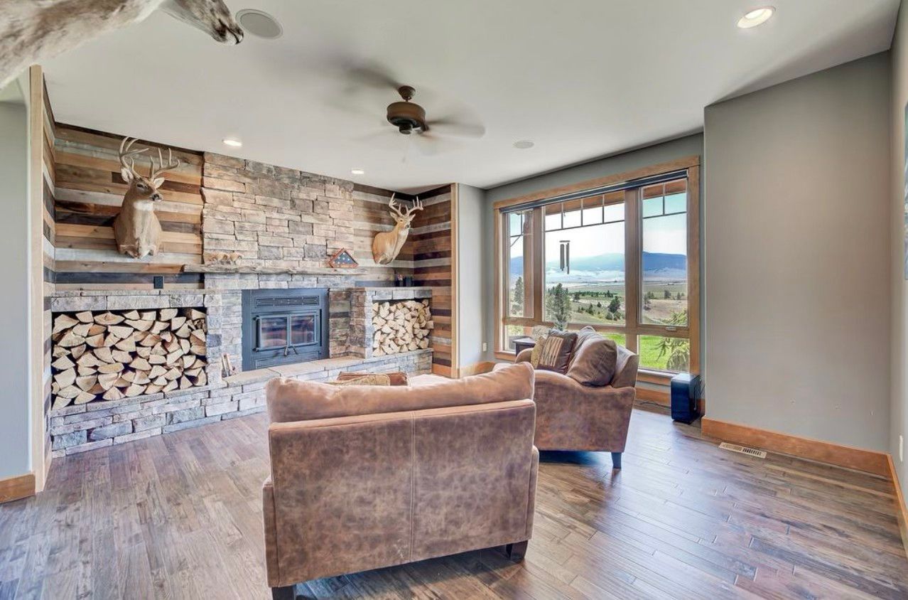A living room with a fireplace , chairs and a couch.