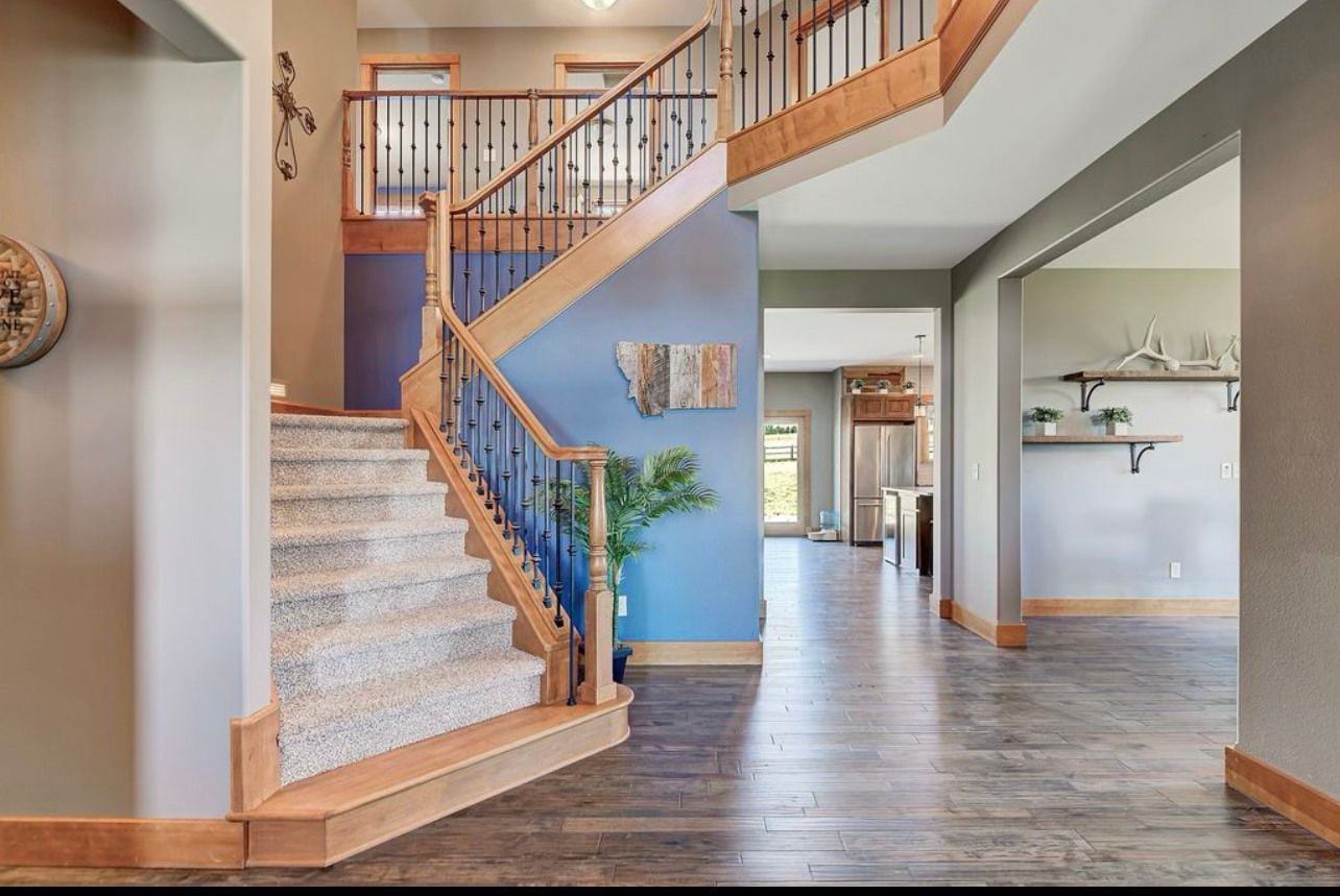 There is a staircase in the middle of the room leading up to the second floor.