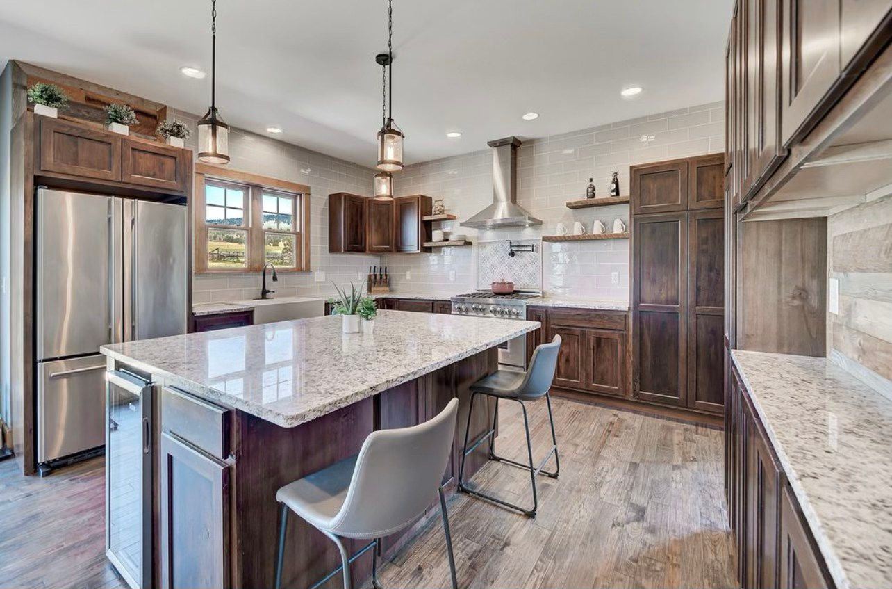 A kitchen with stainless steel appliances , granite counter tops , and wooden cabinets.
