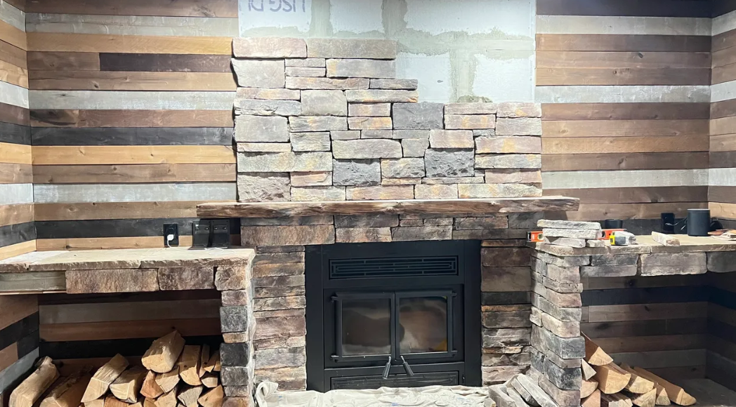 A fireplace is being built in a log cabin.